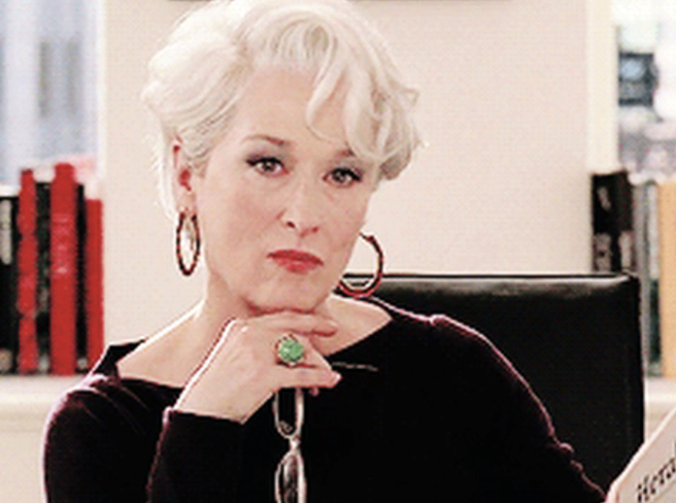 Miranda Priestly from 'The Devil Wears Prada' rests chin on hand, showing off large ring, with a contemplative expression