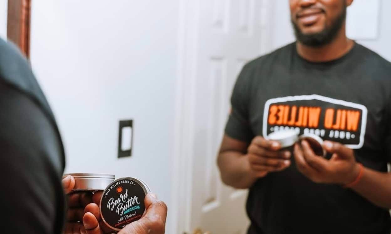 man looking in mirror showing off beard butter