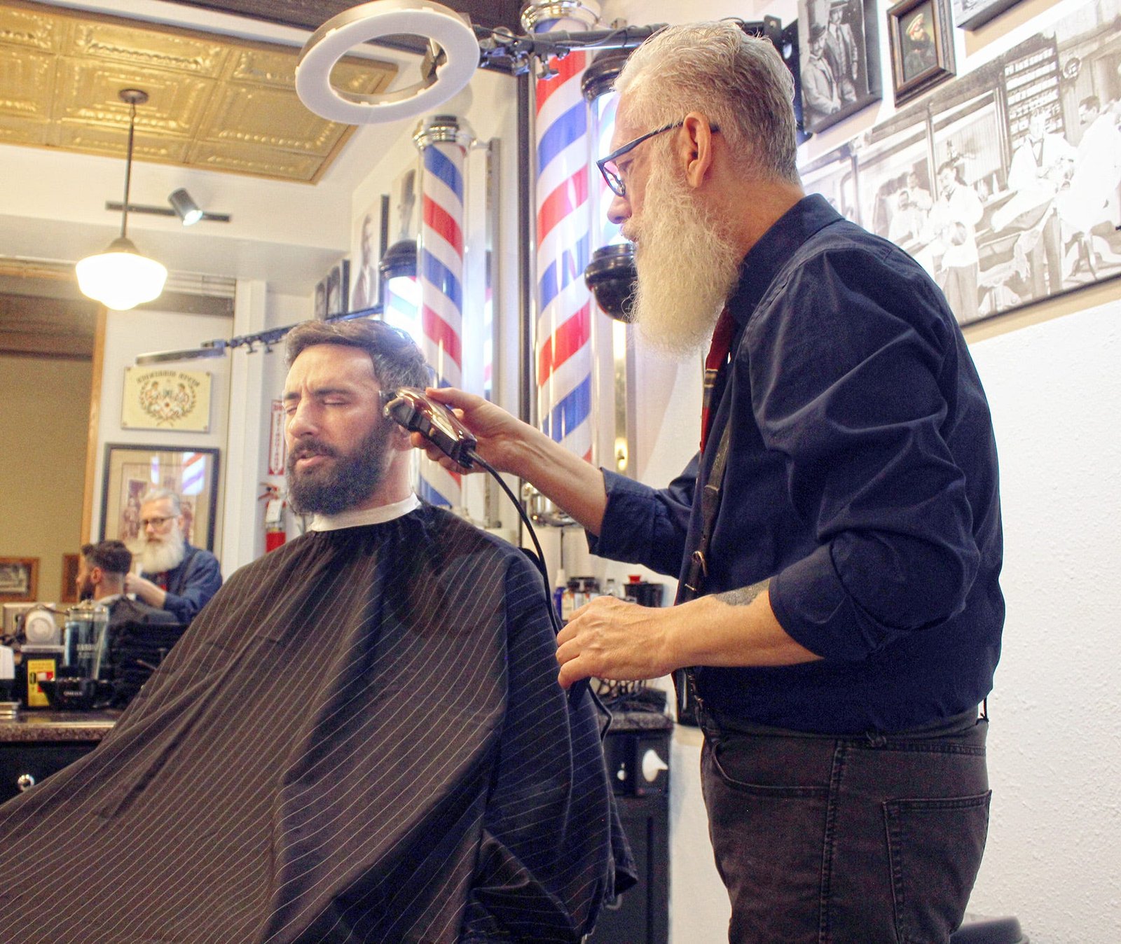 Gentlemen's Barbershop Owner Nick Mischel cutting customer Tony Harper's hair