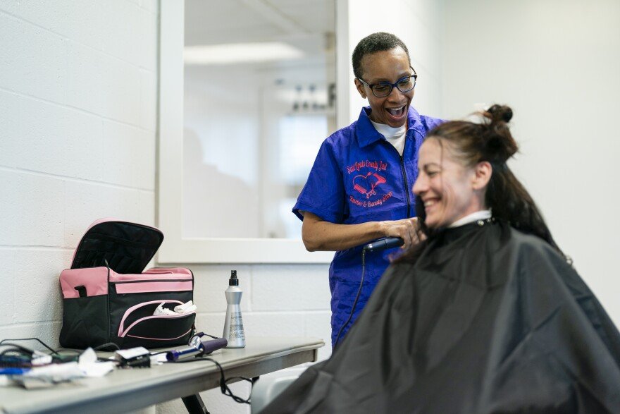 Tammy Townsend, 56, laughs as she works withNichole Zeable’s, 46, during a barber and beauty school class on Tuesday, March 12, 2024, at the St Louis County Jail in Clayton.